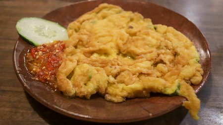 A plate of omelette egg with deep fried cook and traditional sambal or mashed chili sauce. Indonesian style cuisine.の写真素材