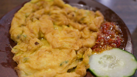 A plate of omelette egg with deep fried cook and traditional sambal or mashed chili sauce. Indonesian style cuisine.の写真素材