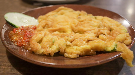 A plate of omelette egg with deep fried cook and traditional sambal or mashed chili sauce. Indonesian style cuisine.の写真素材