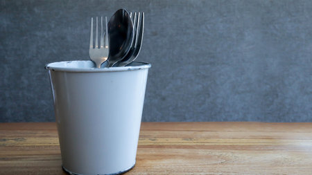 Spoon and fork in a can glass or tin glass as a tableware.の写真素材