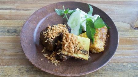 Enjoy fried oxtail beef with cucumber, basil, fried tofu, and tempeh for a delightful blend of flavors and textures.の写真素材
