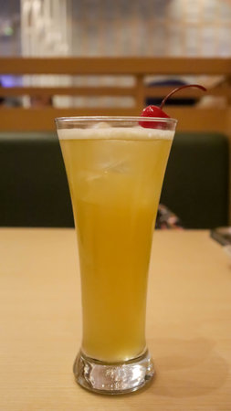 Indulge in a glass of yellow Iced Mango Tea, a thirst quenching fusion of mango and tea, served over ice for a cool, tropical refreshment.の写真素材