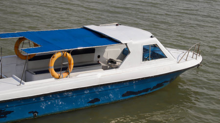 Small passenger motor boat with nobody inside docking, parking or floating in the water.の写真素材