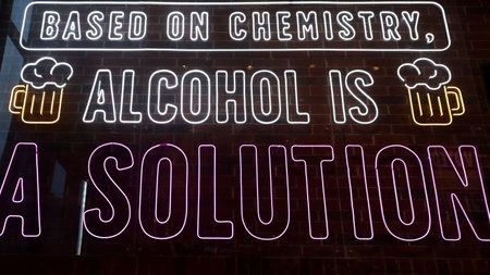 Neon Sign Display with Humorous Chemistry and Alcohol Quote in Bright White and Purple Letters on a Brick Wall Backgroundの写真素材