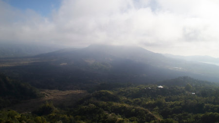 Morning View of Mount Batur Kintamani with Lush Green Forests and Misty Clouds Overlooking the Scenic Landscape in Bali Indonesiaの写真素材