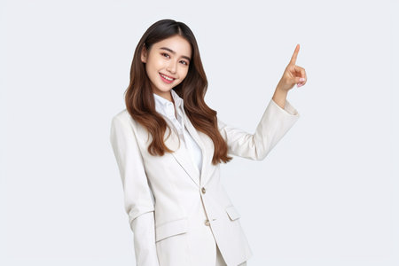 Portrait of a young businesswoman pointing at copy space isolated on white backgroundの素材