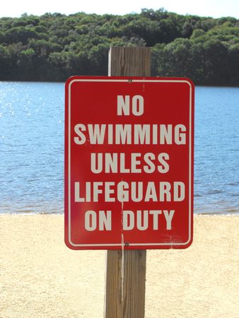 no swimming unless lifeguard on duty sign on beachの写真素材