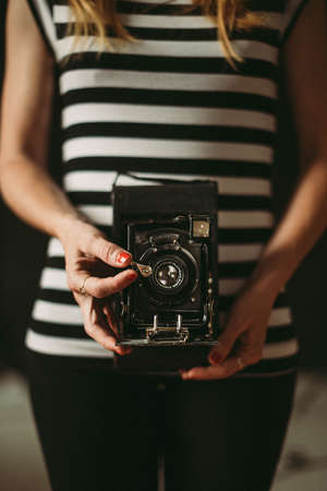 young blonde woman with vintage photo camera