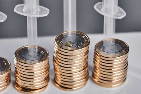 syringes on a mountain of money. covid vaccine. High quality photo