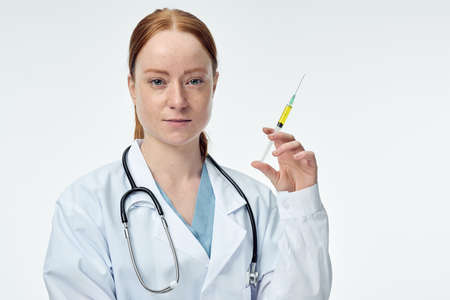 young female doctor shows syringe with forehead vaccine. High quality photoの写真素材