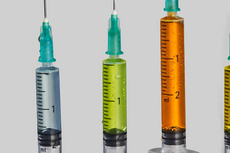 close-up of four syringes with colored vaccine. High quality photoの写真素材