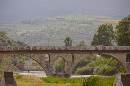 Travel Albania - Old ottoman bridge across the river color of blue in Albania.の写真素材