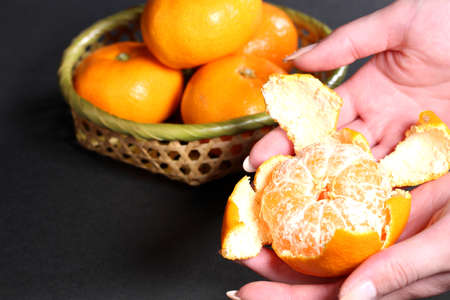 Female have fresh peeled mandarin orangeの写真素材