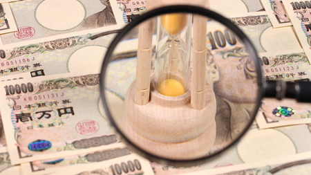 Japanese yen bill and magnifying glass and hourglassの写真素材