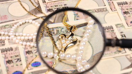 Japanese yen bill and magnifying glass and jewelryの写真素材