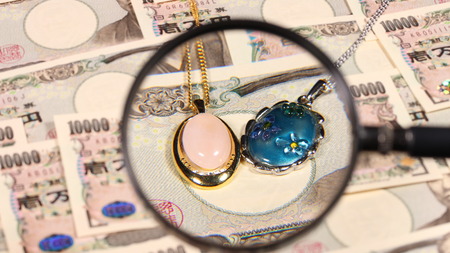Japanese yen bill and magnifying glass and jewelryの写真素材