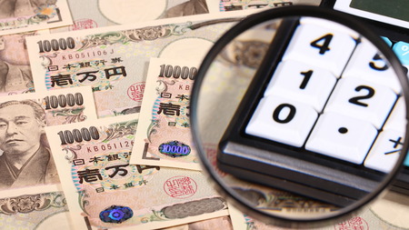 Japanese yen bill and magnifying glass and calculatorの写真素材