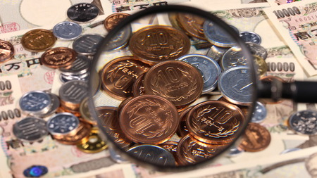 Japanese yen bill and magnifying glass and coinsの写真素材