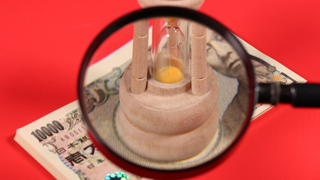 Japanese yen bill and magnifying glass and hourglassの写真素材