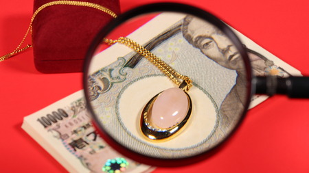 Japanese yen bill and magnifying glass and jewelryの写真素材