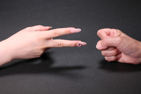 Female and senior are playing rock paper scissors