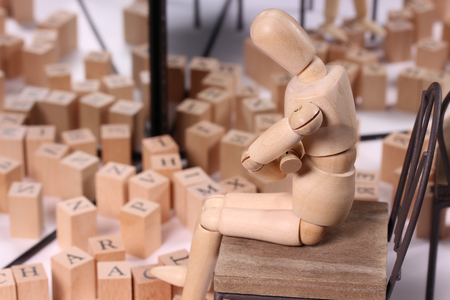 Alphabet block and wooden doll reflecting in the mirrorの写真素材