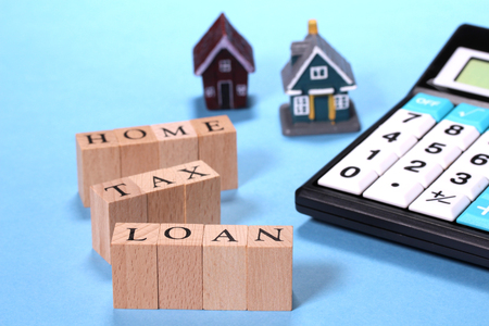 Concept image of buy house... miniature house and calculator and wooden block with letter