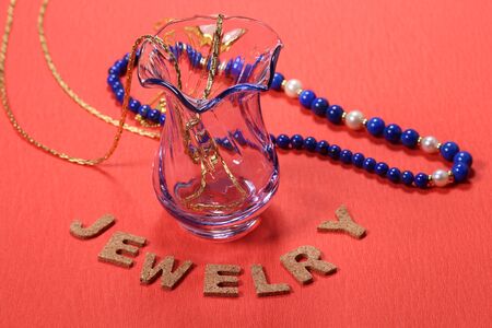 Jewelry in the glassware on red backgroundの写真素材