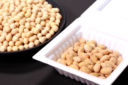 soybeans and packed natto on black background