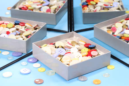 Colorful sewing buttons in a box reflecting in the mirror