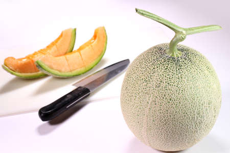 Fresh ripe melon and cutting board, kitchen knifeの写真素材