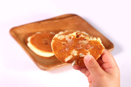 Toddler's hand holding a miso flavor senbei (rice cracker) with peanutsの写真素材