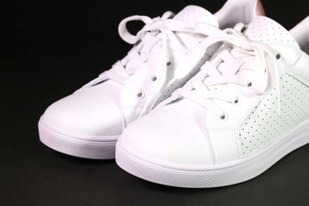 White sneakers on black background