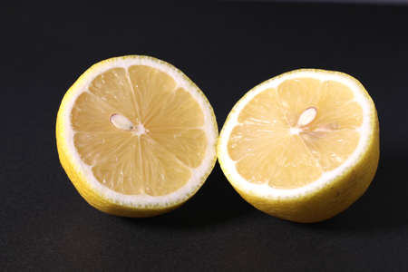 Cutted fresh lemon isolated on black backgroundの写真素材