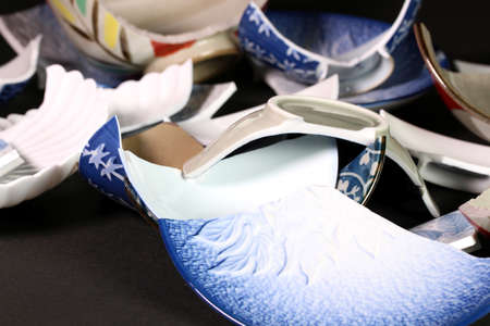 Many broken tableware on black background