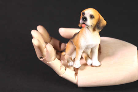 Dog figurine on a wooden handの写真素材