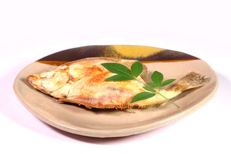 Grilled flounder fish on a plate on white backgroundの写真素材