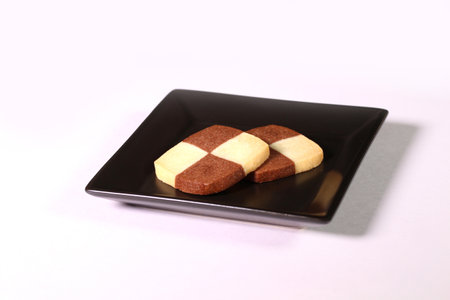 Checkerboard cookies on a plate on white backgroundの写真素材