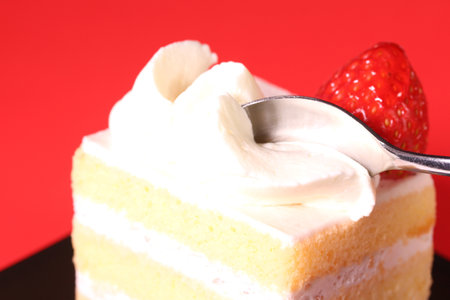 Eating strawberry shortcake with spoonの写真素材