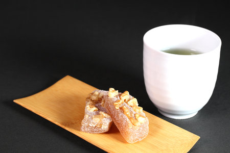 Japanese traditional sticky sweets, Walnut Yubeshi and green tea on black backgroundの写真素材