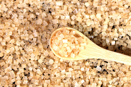 Brown cane sugar and wooden spoon close upの写真素材