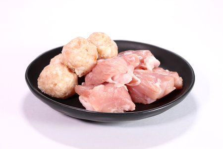 Raw chicken thighs fillet and  chicken meatballs on a plateの写真素材