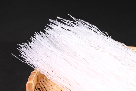 Asian vermicelli on a colander on black backgroundの写真素材