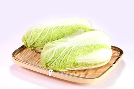 Mini chinese cabbage on a colander on white backgroundの写真素材