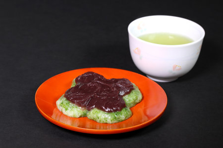 Japanese Kusamochi (mugwort rice cake) with red bean paste and green teaの写真素材