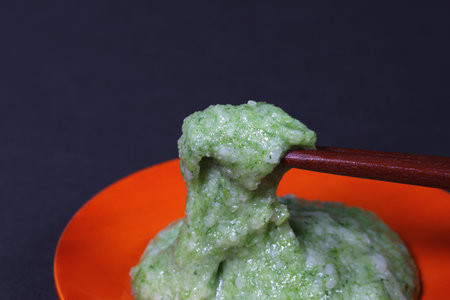 Eating japanese Kusamochi (mugwort rice cake) with chopsticksの写真素材