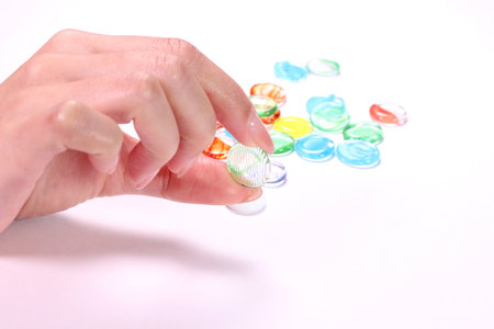 Woman's hand holding a glass marbleの写真素材