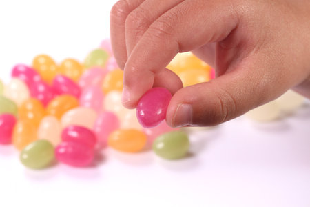 Child's hand holding fruit gummy