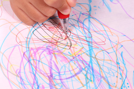 Child drawing with ballpoint pen on white paper, close-upの写真素材