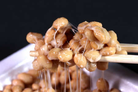 Eating japanese food Natto (fermented soybeans) with 
chopsticksの写真素材